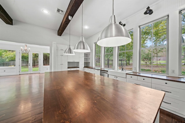 interior space featuring a sink, beam ceiling, visible vents, and butcher block counters