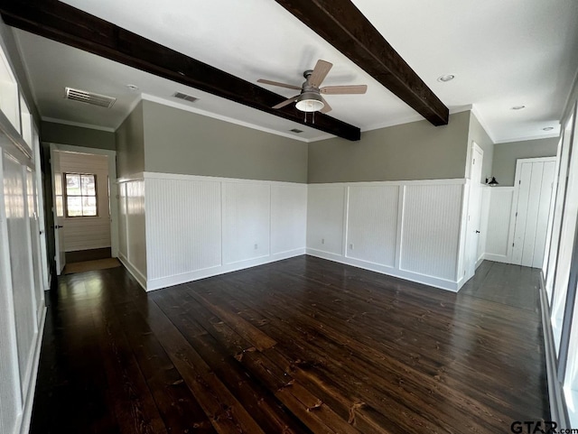 unfurnished living room with a wainscoted wall, beamed ceiling, visible vents, and dark wood-style flooring