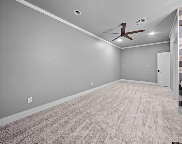 spare room with visible vents, ornamental molding, carpet, baseboards, and ceiling fan