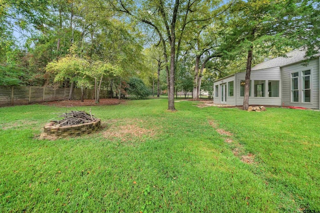 view of yard featuring a fire pit and fence