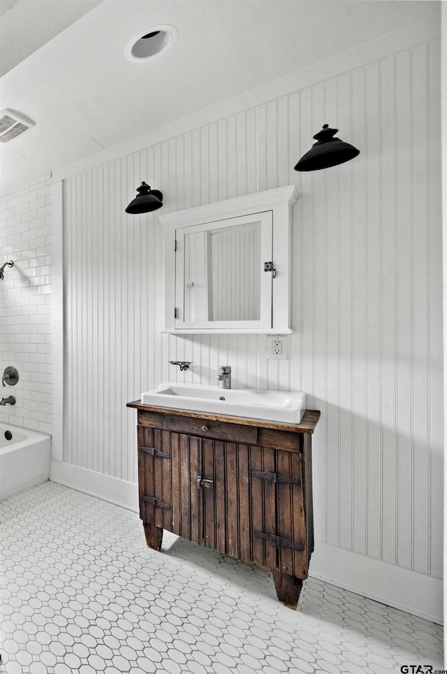 bathroom with tile patterned floors, visible vents, vanity, and bathing tub / shower combination