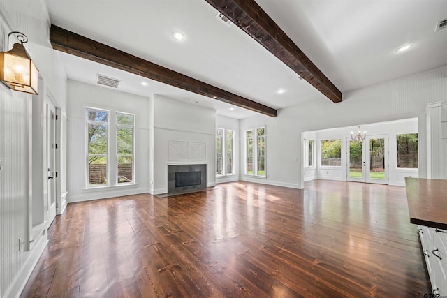 unfurnished living room with beam ceiling, a fireplace with flush hearth, visible vents, and wood-type flooring