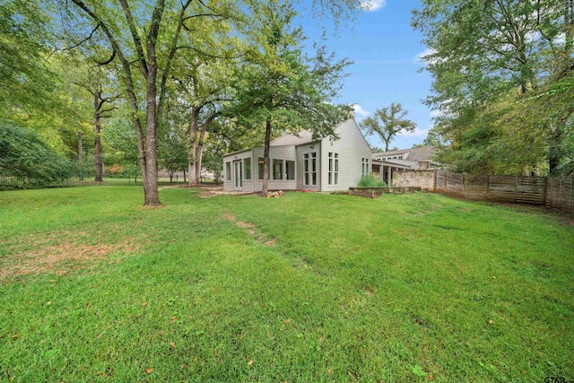 view of yard featuring a sunroom and fence