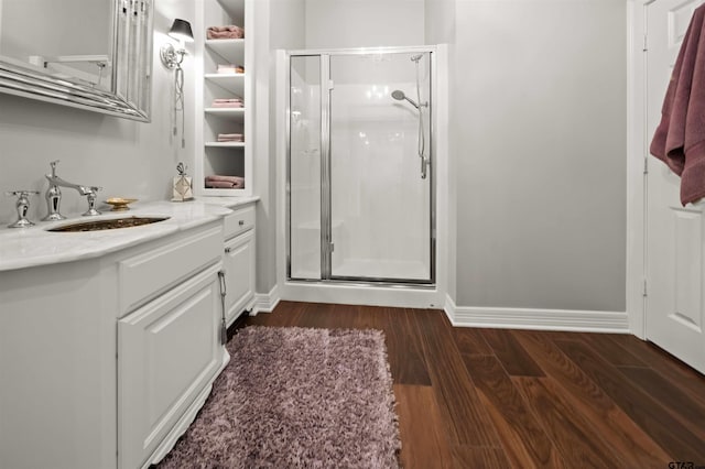 bathroom with vanity, a shower with shower door, and hardwood / wood-style flooring