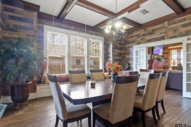 dining room featuring beam ceiling, wooden walls, and dark hardwood / wood-style floors