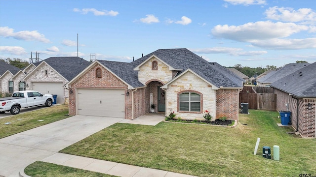 view of front of home featuring a garage, central air condition unit, and a front lawn