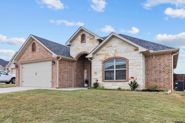 view of front of property featuring central AC, a front yard, and a garage