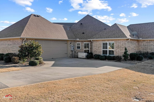 ranch-style home featuring a garage and a front lawn