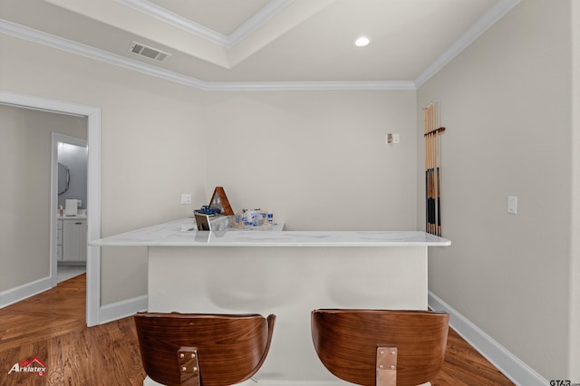 bar with hardwood / wood-style floors and crown molding