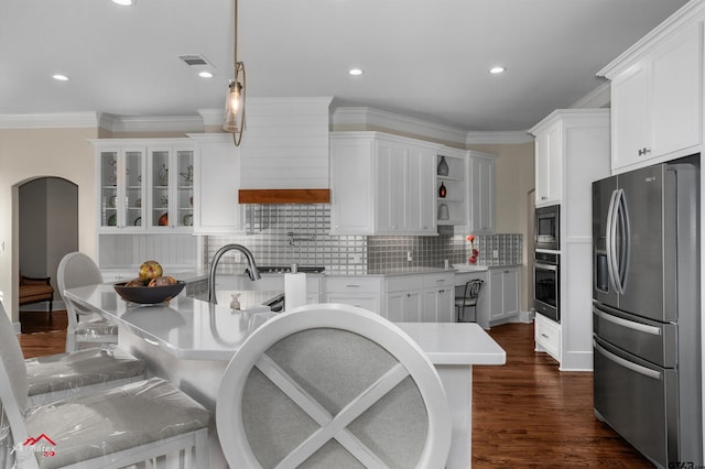 kitchen with appliances with stainless steel finishes, hanging light fixtures, backsplash, dark hardwood / wood-style floors, and white cabinets