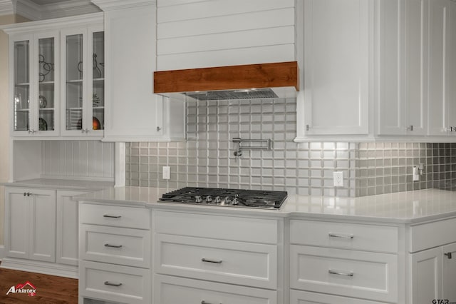 kitchen featuring white cabinetry, decorative backsplash, custom exhaust hood, and stainless steel gas cooktop