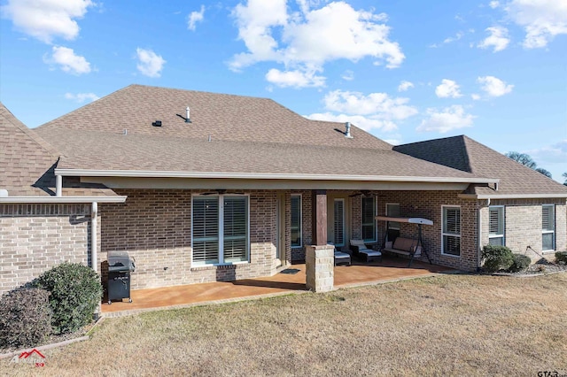 rear view of property featuring ceiling fan, a patio, and a lawn