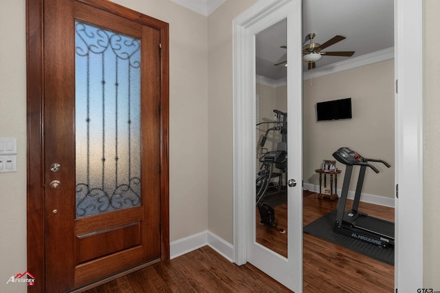 foyer entrance with dark wood-type flooring, ornamental molding, french doors, and ceiling fan