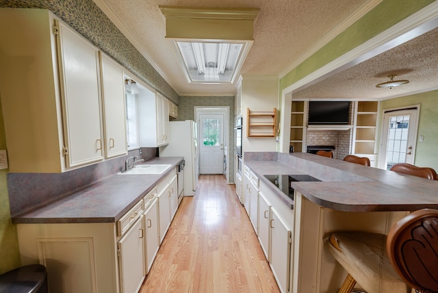 102 King Henry Rd, Scroggins, TX 75480 - kitchen featuring a sink, a textured ceiling, light wood-type flooring, black electric cooktop, and ornamental molding
