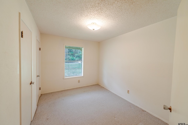 102 King Henry Rd, Scroggins, TX 75480 - unfurnished bedroom featuring a textured ceiling and light carpet