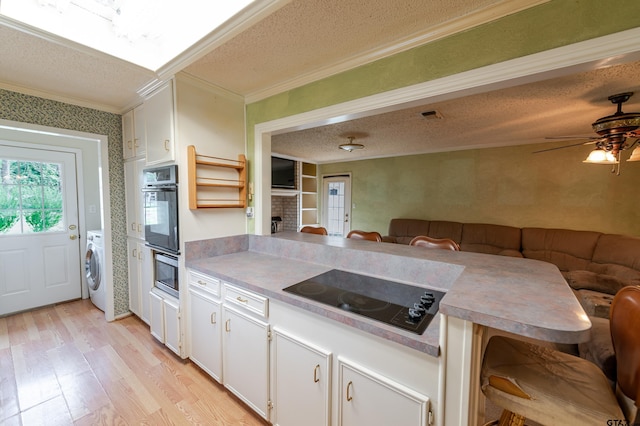 102 King Henry Rd, Scroggins, TX 75480 - kitchen featuring crown molding, a textured ceiling, washer / clothes dryer, black appliances, and light wood-style floors