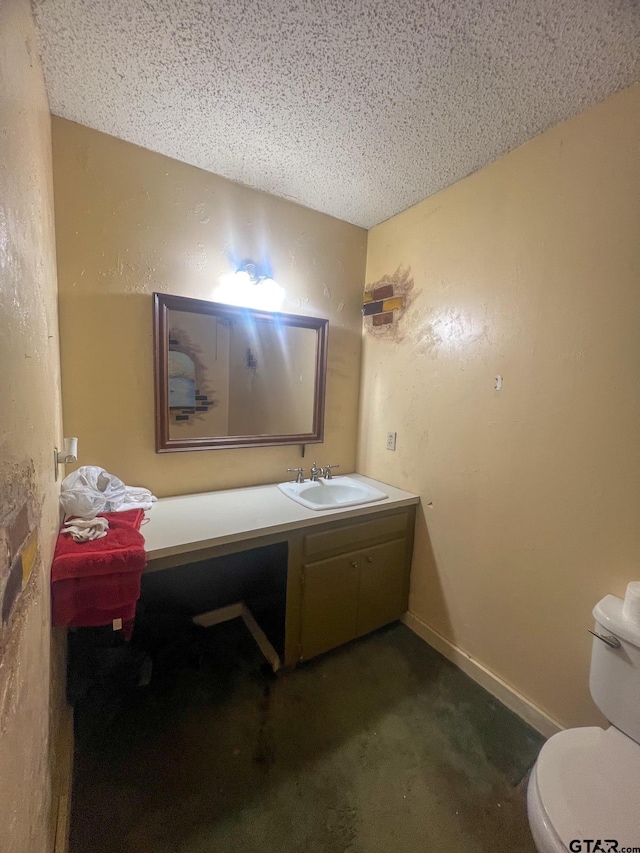 bathroom featuring vanity, a textured ceiling, and toilet