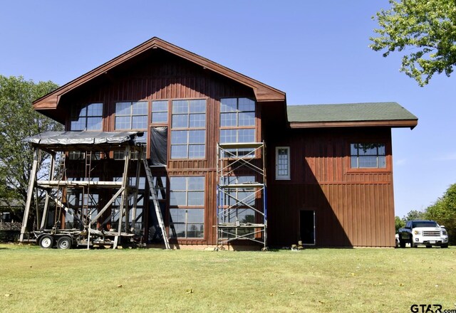 rear view of house featuring a yard