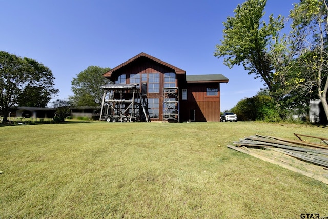 back of property with a lawn and an outdoor structure