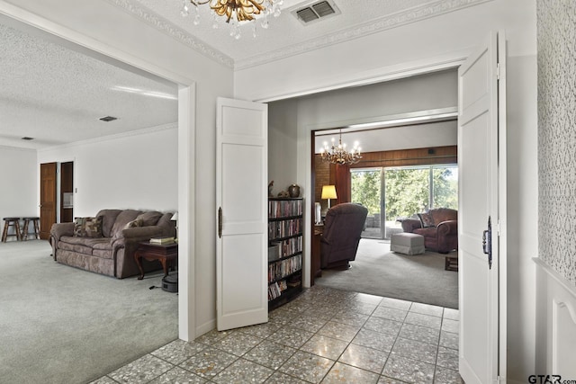 hallway with carpet, a textured ceiling, and an inviting chandelier