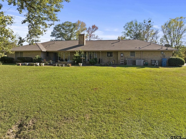 back of property featuring a lawn and cooling unit