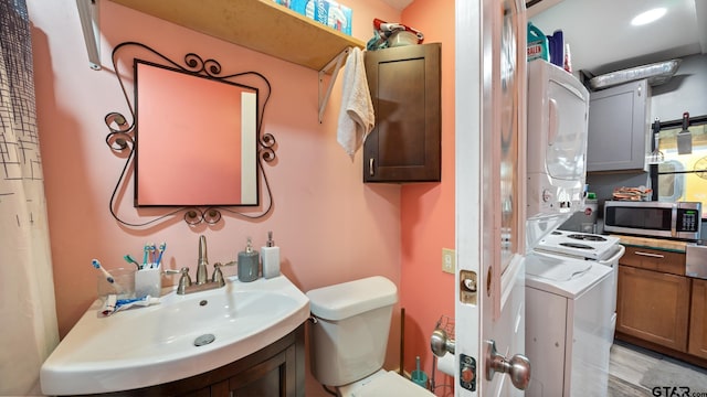 bathroom with stacked washer / dryer, toilet, and sink