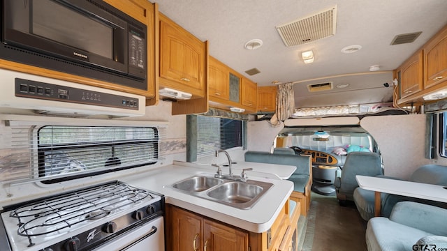 kitchen featuring sink, gas stove, and black microwave