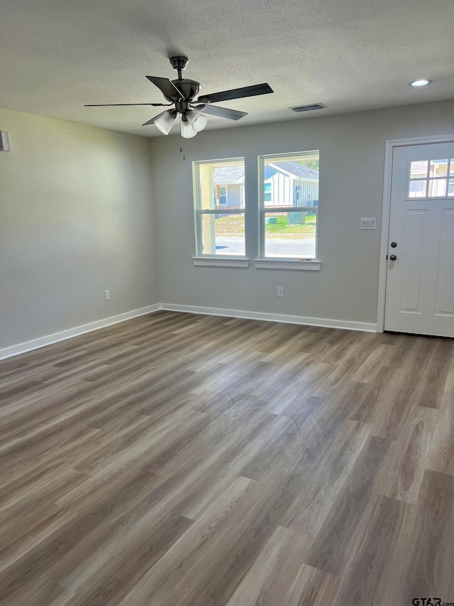 entryway with ceiling fan, hardwood / wood-style floors, and a textured ceiling