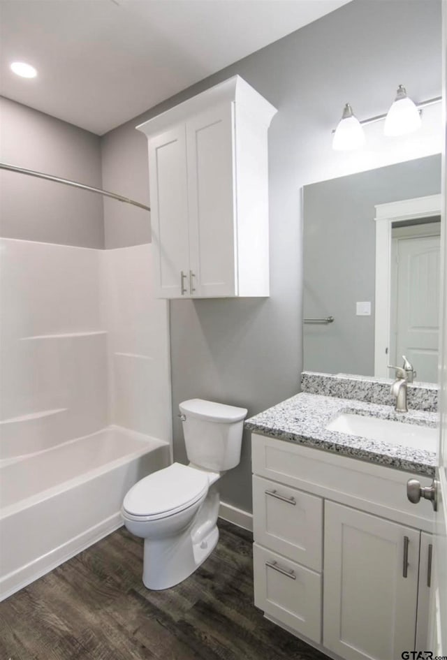 full bathroom with toilet, vanity, shower / bathtub combination, and hardwood / wood-style flooring