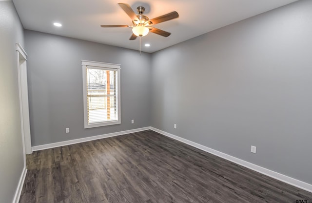 spare room featuring dark hardwood / wood-style flooring and ceiling fan