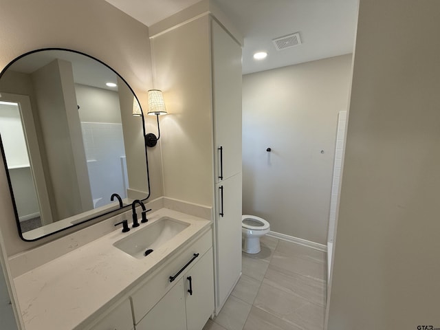 bathroom with tile patterned flooring, vanity, and toilet