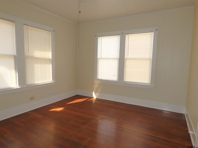 unfurnished room with ornamental molding and dark wood-type flooring