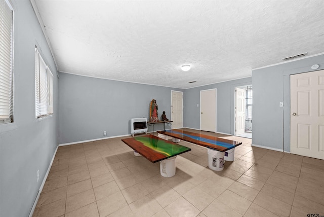 rec room featuring a textured ceiling, light tile patterned floors, and heating unit