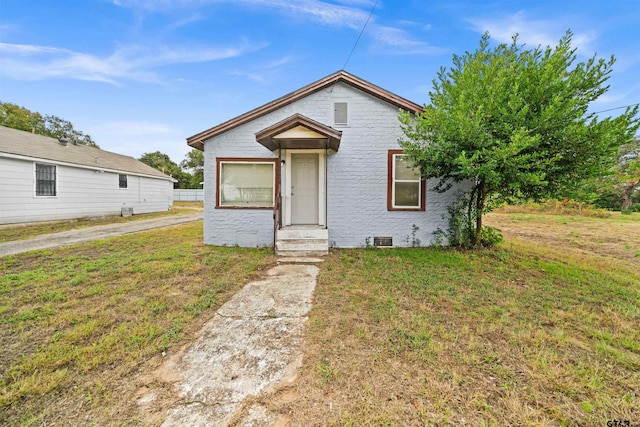 bungalow-style house featuring a front yard