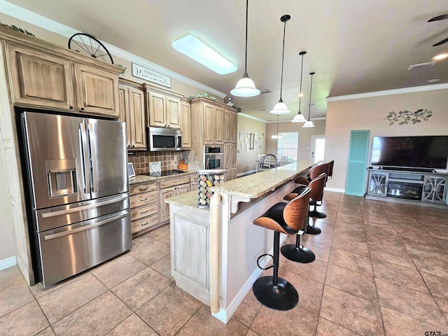 kitchen featuring a kitchen bar, an island with sink, tasteful backsplash, light stone counters, and stainless steel appliances