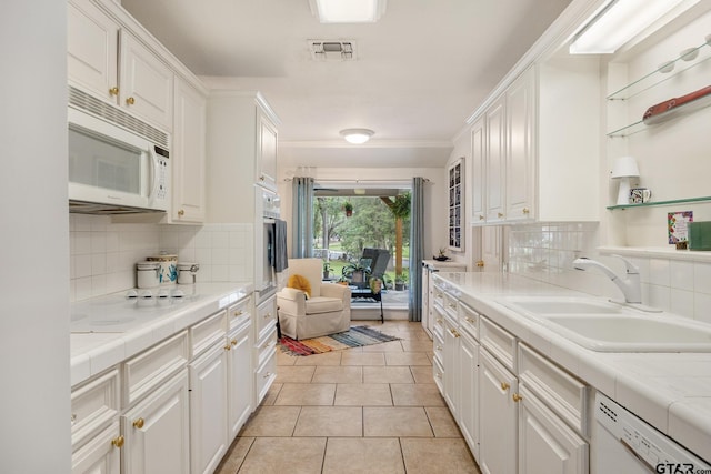 312 Savannah Dr, Tyler, TX 75703 - kitchen featuring white appliances, white cabinets, backsplash, light tile patterned floors, and ornamental molding