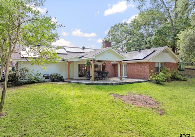 312 Savannah Dr, Tyler, TX 75703 - view of front facade featuring roof mounted solar panels, a patio, a chimney, and a front yard