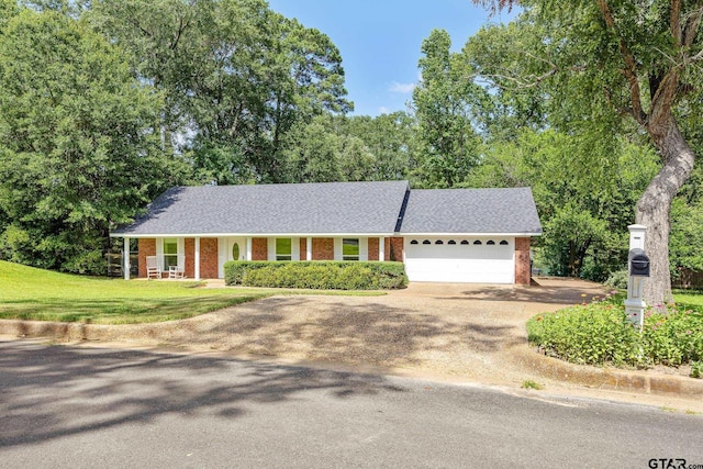 312 Savannah Dr, Tyler, TX 75703 - view of front of house with driveway, a garage, a front yard, brick siding, and a shingled roof