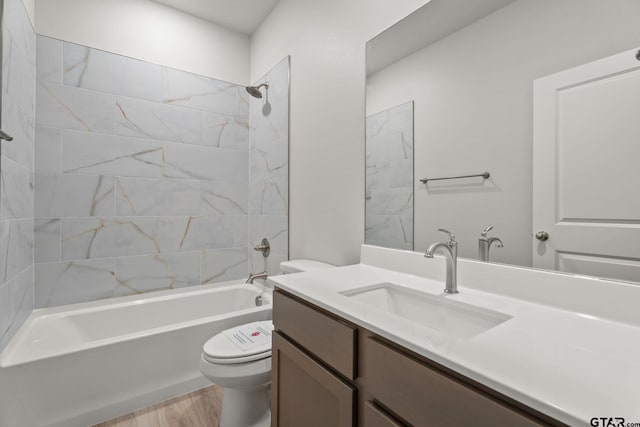 full bathroom featuring hardwood / wood-style floors, vanity, toilet, and tiled shower / bath