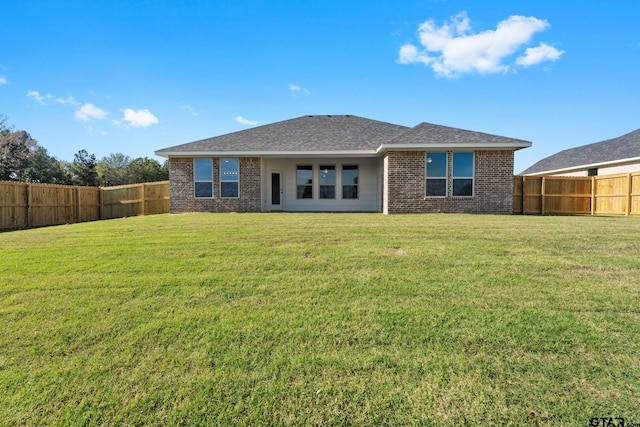 rear view of property with a yard