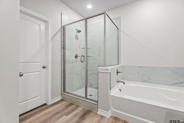 bathroom with plus walk in shower and hardwood / wood-style floors