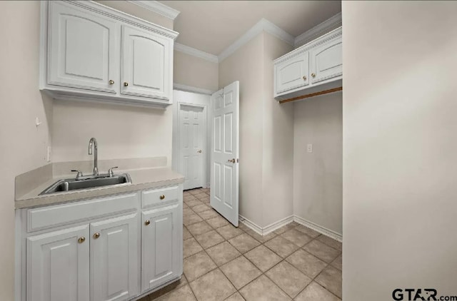 2107 Baylor Dr, Jacksonville, TX 75766 - kitchen with a sink, crown molding, white cabinets, light countertops, and light tile patterned floors