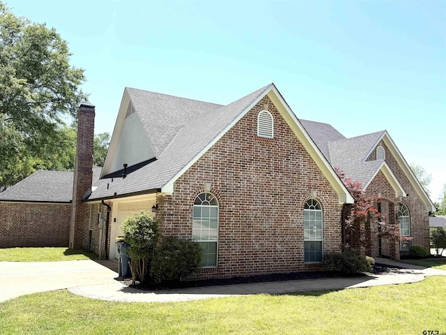 2107 Baylor Dr, Jacksonville, TX 75766 - view of property exterior with brick siding, a garage, a chimney, concrete driveway, and a lawn