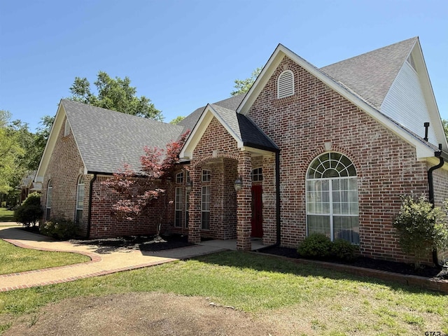 2107 Baylor Dr, Jacksonville, TX 75766 - view of front of property with brick siding, roof with shingles, a front yard, and a patio area