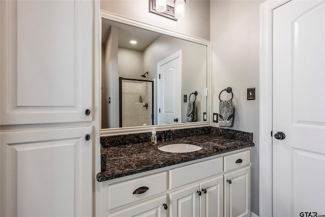 bathroom featuring walk in shower and vanity