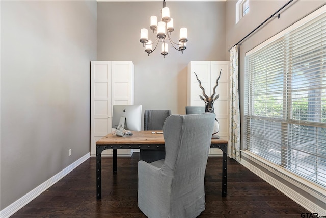 office with dark hardwood / wood-style flooring and an inviting chandelier