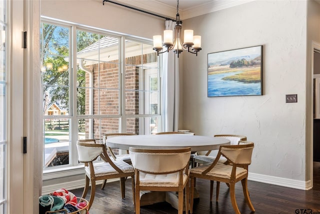 dining area with dark wood-type flooring, a wealth of natural light, an inviting chandelier, and crown molding