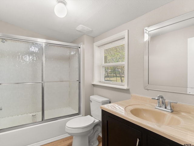 full bathroom featuring vanity, wood-type flooring, enclosed tub / shower combo, toilet, and lofted ceiling