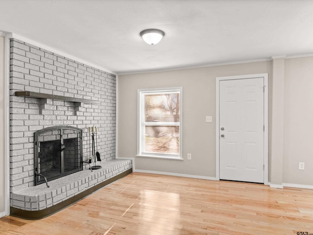 entryway featuring a fireplace, hardwood / wood-style floors, and ornamental molding