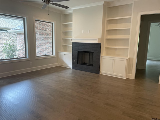 unfurnished living room featuring ceiling fan, a fireplace, dark hardwood / wood-style flooring, and built in features